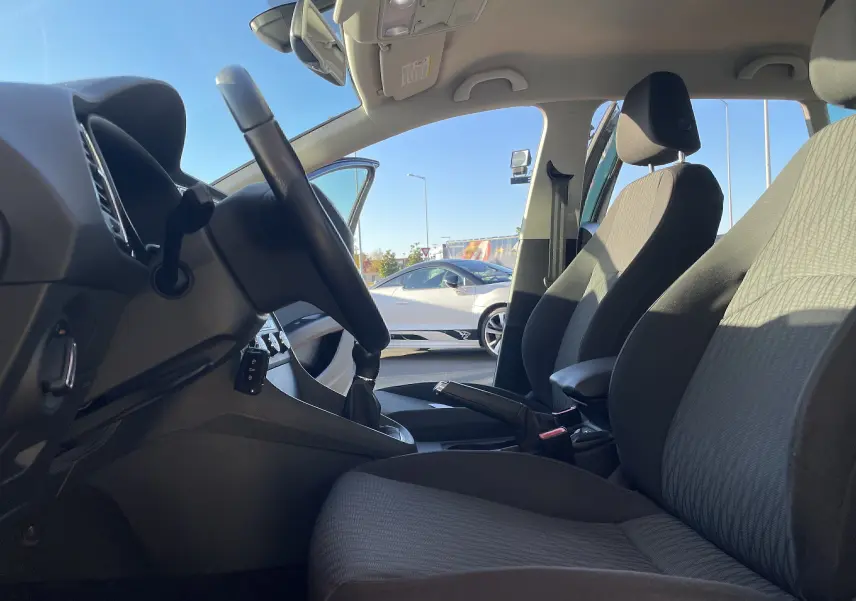 Intérieur gris noir en tissu de la SEAT LEON ST 1.2 TSI 2013, vue côté conducteur avec volant et levier de vitesses manuelle.