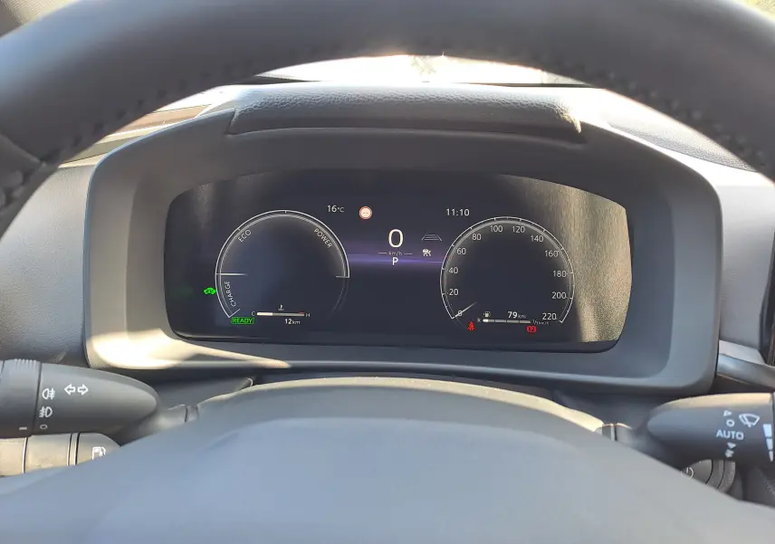 Vue du tableau de bord numérique du Toyota C-HR gris minéral 2025, affichant le mode de conduite et l'autonomie restante.