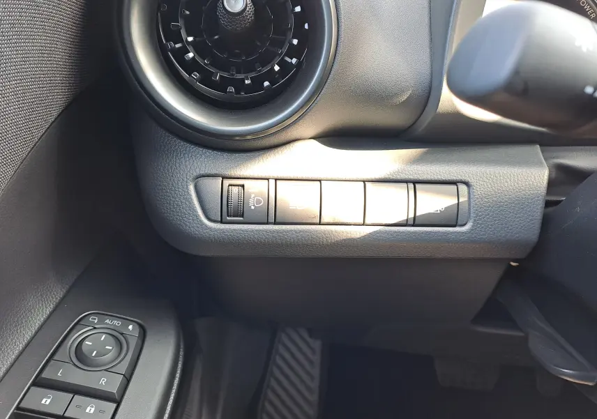 Vue intérieure côté conducteur du Toyota C-HR gris minéral 2025, avec volant multifonction et écran tactile de navigation.