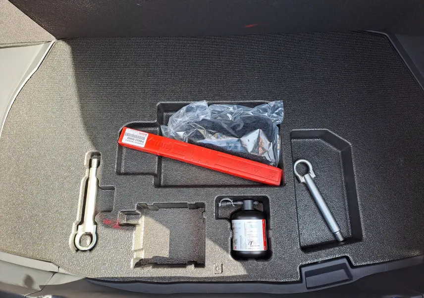 Vue plongeante sur la console centrale et les sièges avant noirs du Toyota C-HR gris minéral 2025 hybride avec boîte auto.