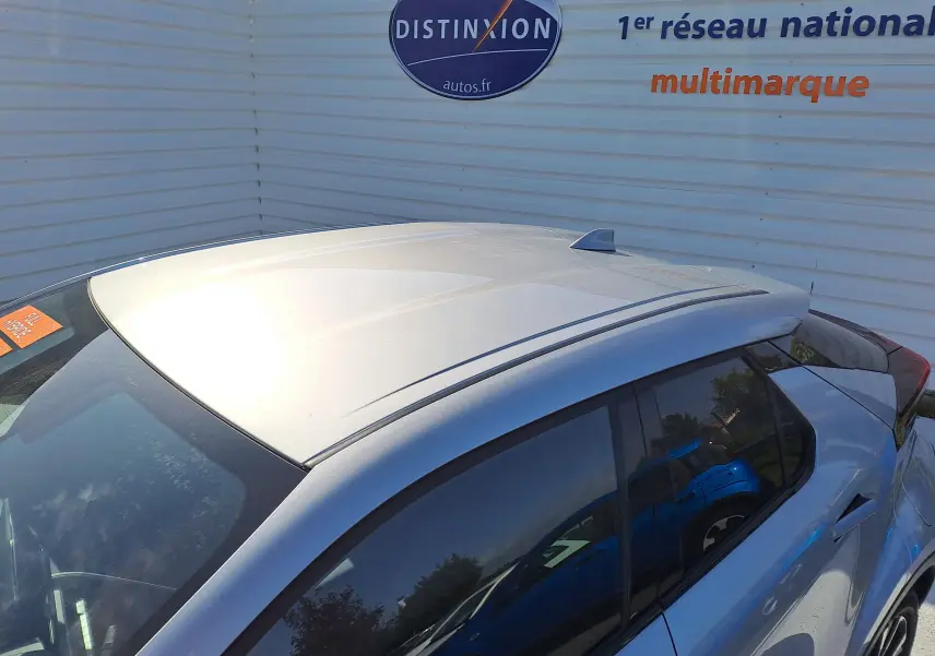 Profil côté gauche du Toyota C-HR 2025 gris minéral avec jantes biton et lignes sculptées distinctives.