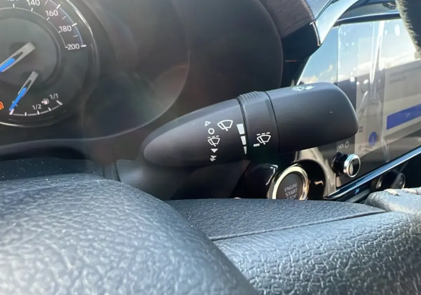 Gros plan sur la commande d'essuie-glace et le tableau de bord noir du Toyota Hilux 2025 gris atlas, version Invincible.