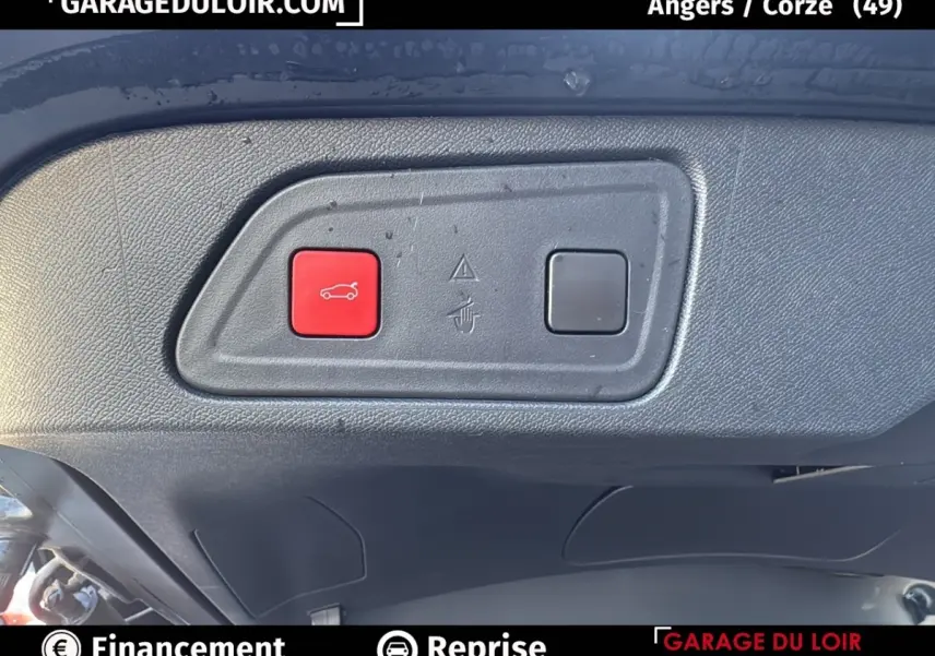 Gros plan sur le bouton rouge d'ouverture du coffre dans le hayon noir du Citroën C5 Aircross 2025.