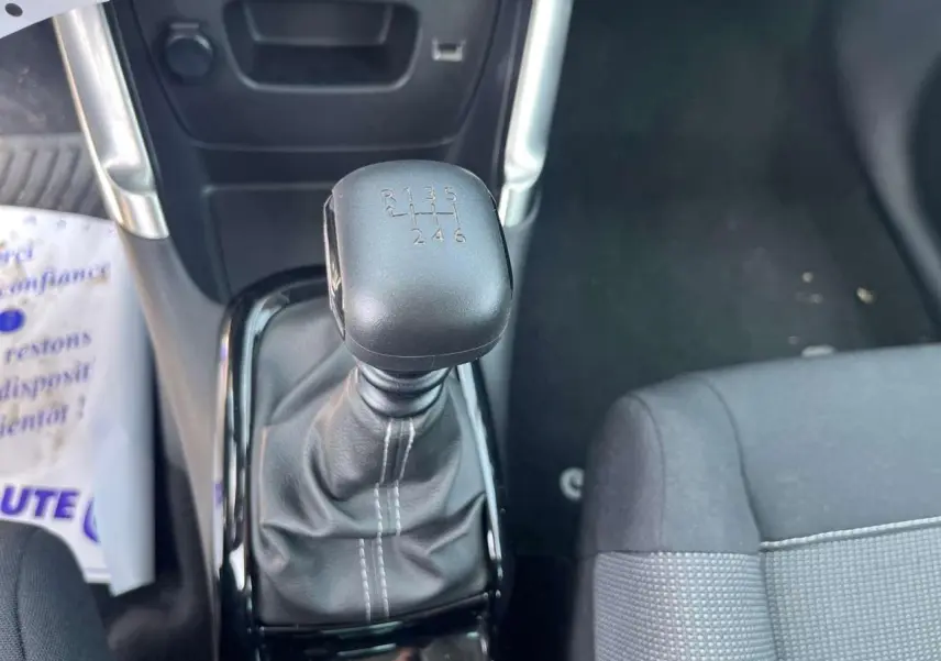 Gros plan sur le levier de vitesses manuel de la Citroën C3 Aircross 2023, intérieur noir avec coutures blanches.