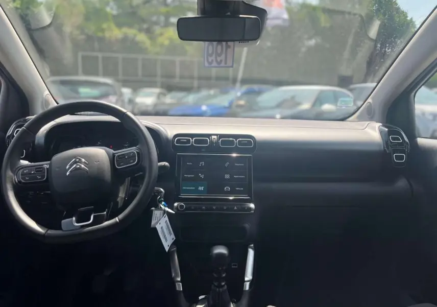 Vue intérieure frontale du tableau de bord noir du Citroën C3 Aircross 2023 avec écran tactile et volant multifonction.