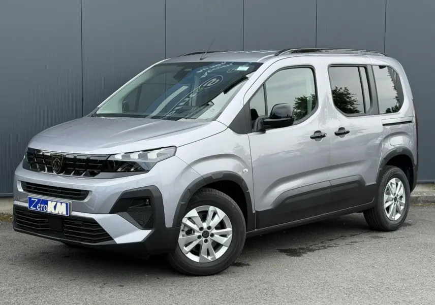 Peugeot Rifter gris acier vu en 3/4 avant droit, avec jantes alu 16 pouces et portes latérales coulissantes.