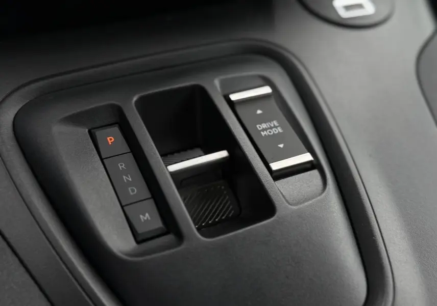 Gros plan sur la console centrale noire du Peugeot Rifter 2026 avec commandes boîte auto et sélection mode de conduite.