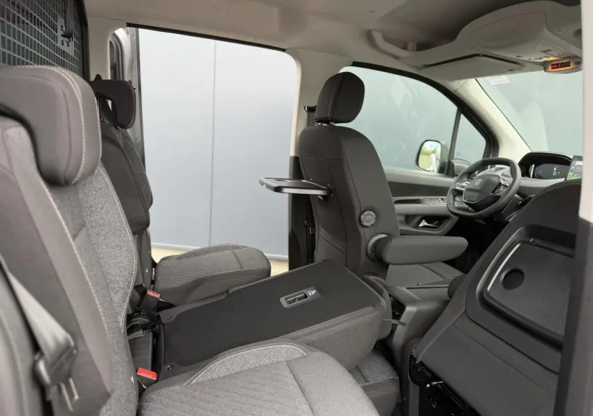 Vue intérieure côté droit du Peugeot Rifter gris acier 2026, montrant les sièges individuels et la tablette rabattable.