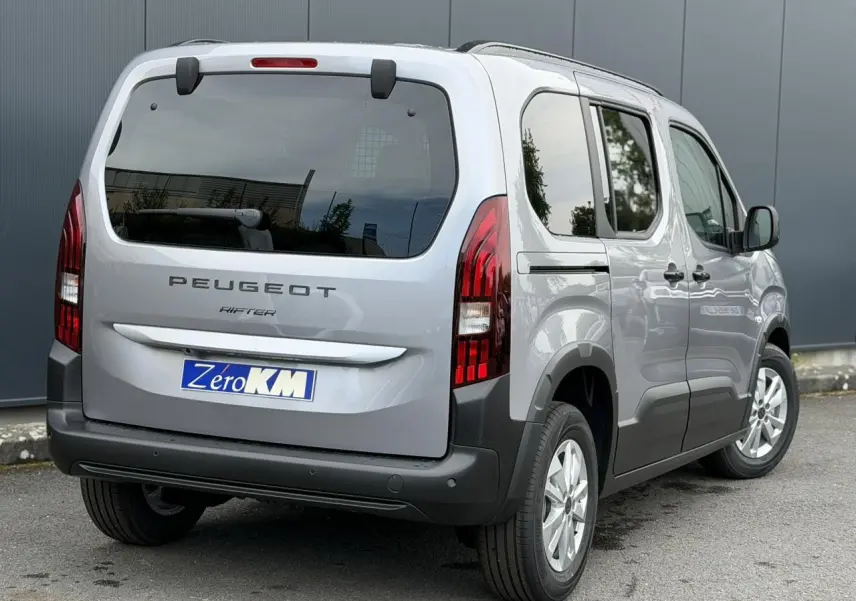 Vue 3/4 arrière droite du Peugeot Rifter gris acier 2026 avec portes latérales coulissantes et feux arrière LED distinctifs.
