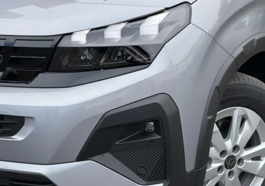 Gros plan sur l’avant droit gris acier du Peugeot Rifter 2026, mettant en valeur le phare LED et la jante alu.