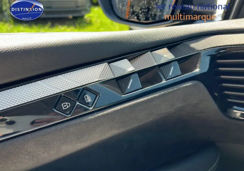 Détail intérieur côté conducteur du DS4 E-tense 225 gris platinium montrant les commandes de verrouillage et de vitres.