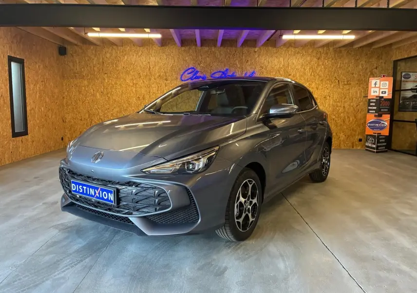 Vue 3/4 avant d’une MG3 gris métallisé 2026 en intérieur, avec calandre noire et jantes au design distinctif.