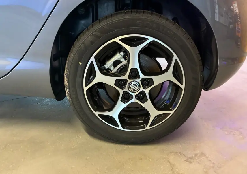 Gros plan sur la roue avant droite noire du MG3 1.5 HYBRID+ 195 LUXURY avec jante alliage bicolore et logo MG central.