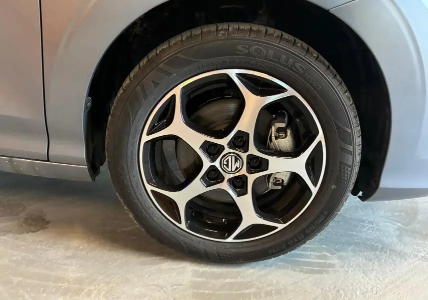 Gros plan sur la roue avant gauche noire du MG3 1.5 HYBRID+ 195 LUXURY avec jante alliage bicolore distinctive.
