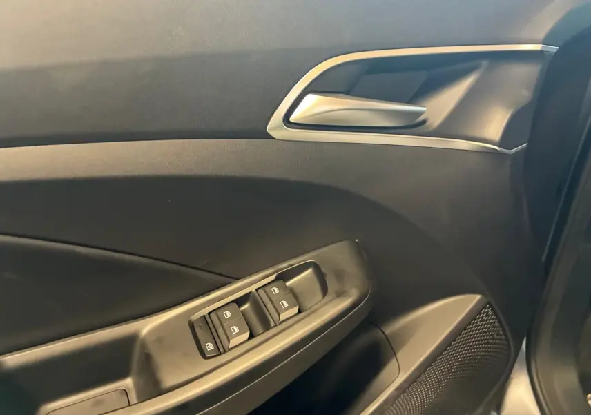 Détail de la porte côté gauche de la MG3 1.5 HYBRID+ 195 LUXURY noire, montrant les commandes des vitres et la poignée intérieure.