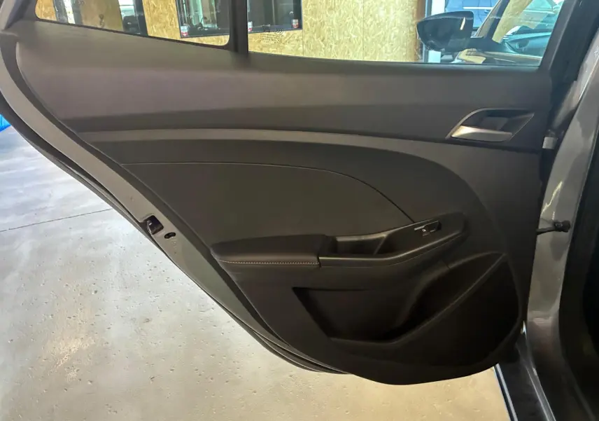 Gros plan sur la porte arrière gauche noire intérieure du MG3 1.5 HYBRID+ 195 LUXURY avec accoudoir et poignée intégrés.