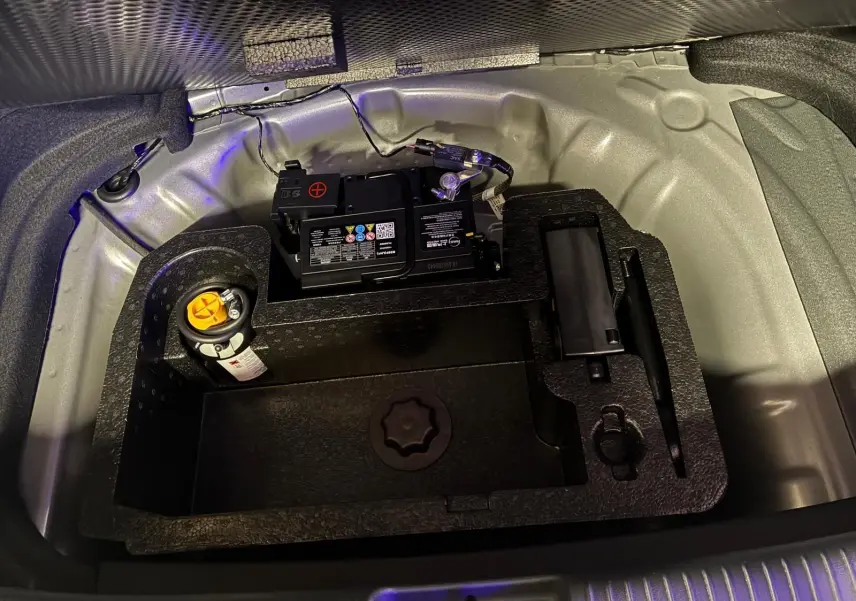 Vue rapprochée du compartiment batterie et outils sous le coffre d'une MG3 1.5 HYBRID+ 195 LUXURY noire, année 2026.