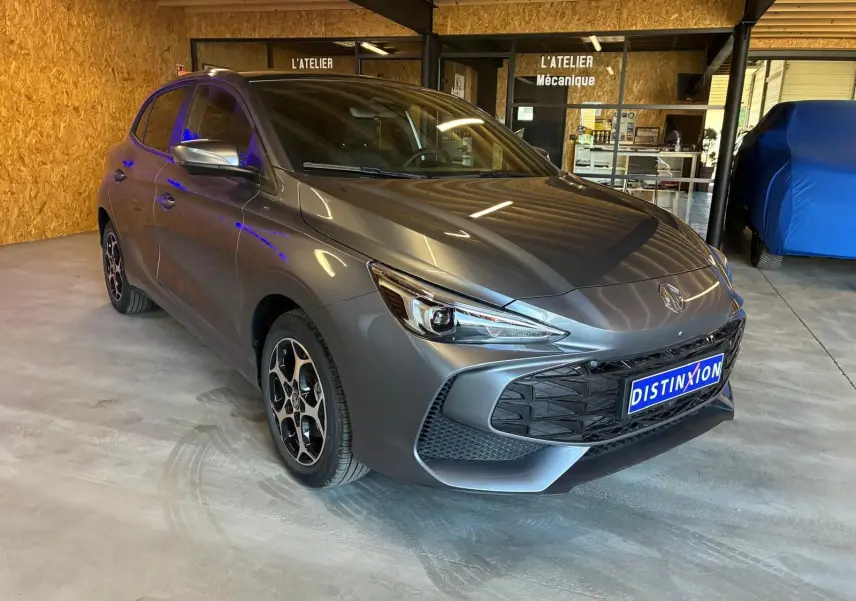 Vue 3/4 avant d'une MG3 1.5 Hybrid+ 195 Luxury gris métallisé, avec jantes noires et détails sportifs visibles.
