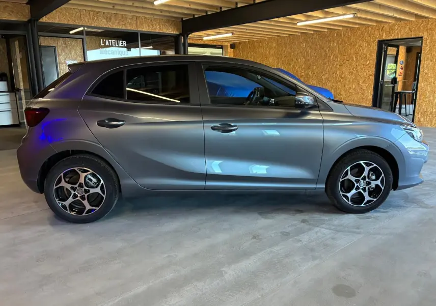 Vue de profil côté gauche d'une MG3 1.5 HYBRID+ 195 LUXURY gris métallisé avec jantes noires et argent.