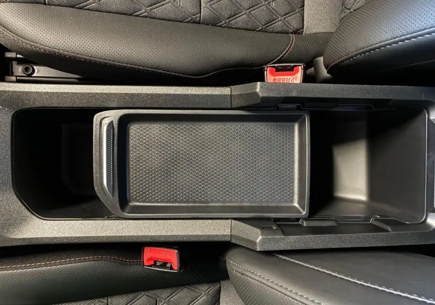 Vue plongeante sur la console centrale noire avec rangement ouvert et sièges en cuir noir du MG3 1.5 HYBRID+ 195 LUXURY.