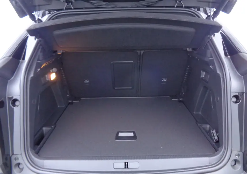 Coffre ouvert vu de l'arrière d'un Peugeot 3008 noir Perla Nera, espace de chargement spacieux et bien éclairé.