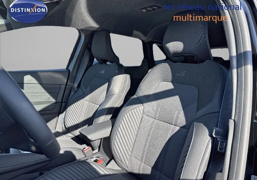 Vue intérieure côté conducteur montrant les sièges avant noirs en tissu et cuir avec logo Alpine brodé sur Renault Symbioz 2025.