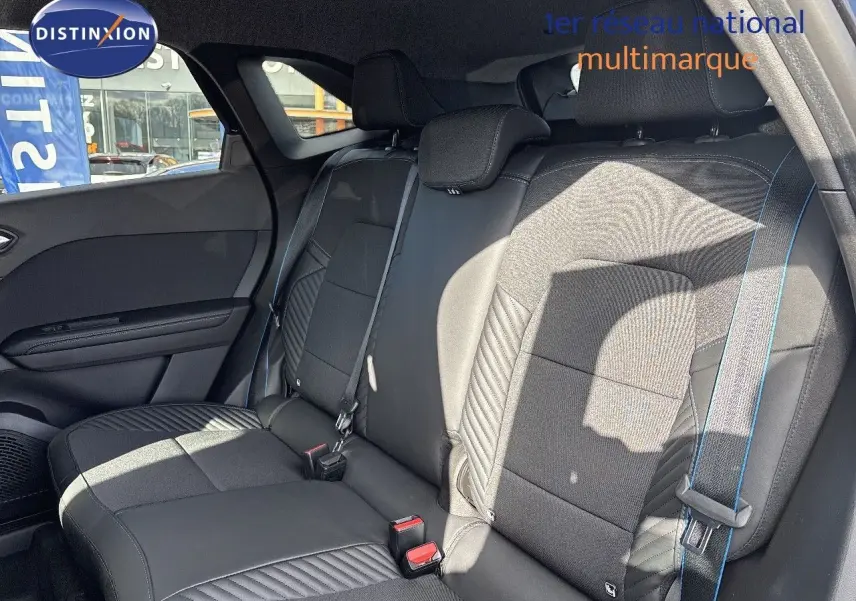 Vue latérale des sièges arrière noirs en cuir et tissu avec surpiqûres bleues du Renault Symbioz hybride 2025.