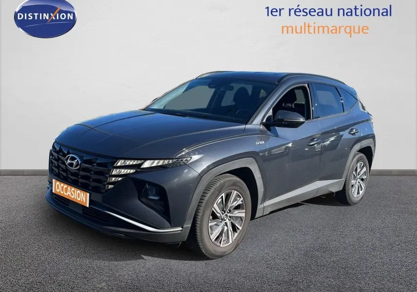 Hyundai Tucson gris foncé métal vu en 3/4 avant droit, avec calandre distinctive et jantes alliage modernes.