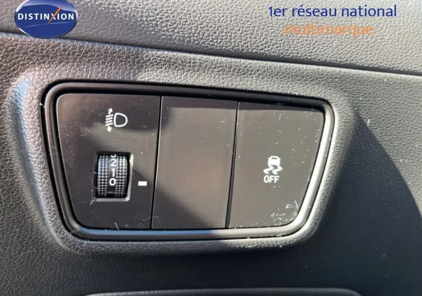 Gros plan sur les commandes de réglage des phares et désactivation de l'ESP dans un Hyundai Tucson gris foncé 2021.