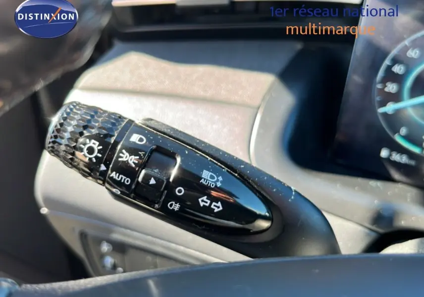 Gros plan sur la commande des feux et clignotants du Hyundai Tucson gris foncé, intérieur tableau de bord visible.