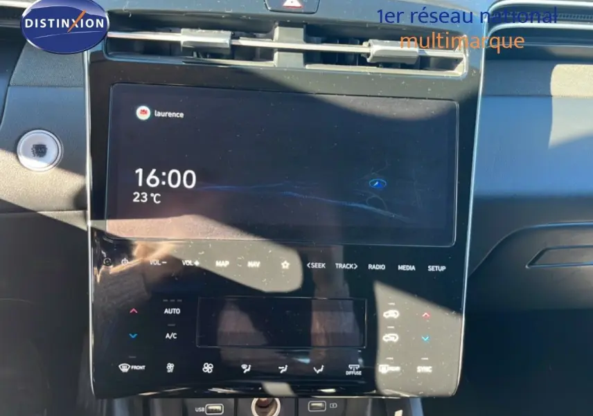 Vue rapprochée de la console centrale tactile du Hyundai Tucson gris foncé, affichant l'heure et la température.