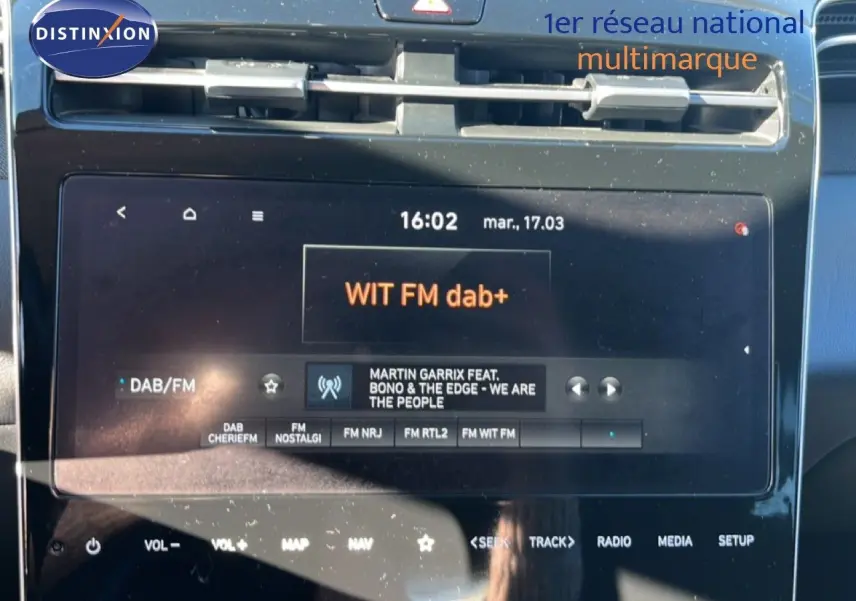 Vue rapprochée de l’écran tactile central du Hyundai Tucson gris foncé, affichant la radio DAB/FM WIT FM dab+.