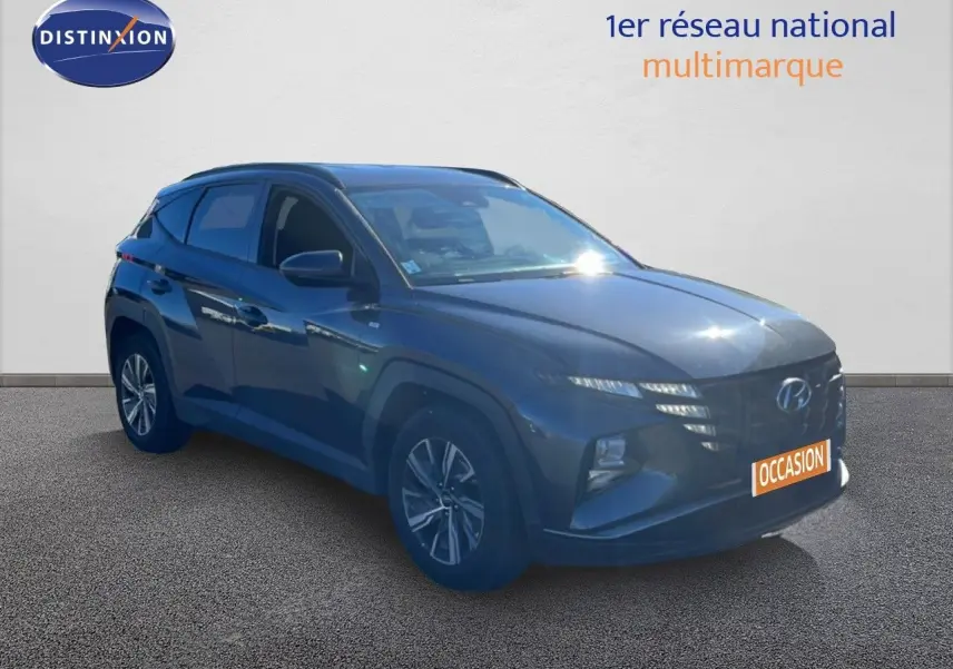 Hyundai Tucson gris foncé métal en 3/4 avant droit, mettant en valeur ses lignes modernes et ses optiques fines.
