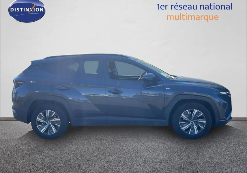 Vue de profil côté gauche du Hyundai Tucson gris foncé métal 2021, soulignant ses lignes modernes et ses jantes alliage.
