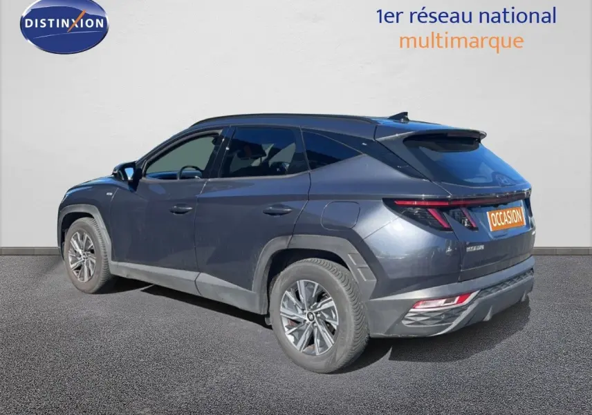 Vue 3/4 arrière gauche du Hyundai Tucson gris foncé métal avec feux arrière LED et jantes alliage.