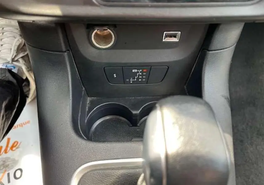Gros plan sur la console centrale de la Citroën C3 2023, montrant le levier de boîte automatique et prises USB et 12V.