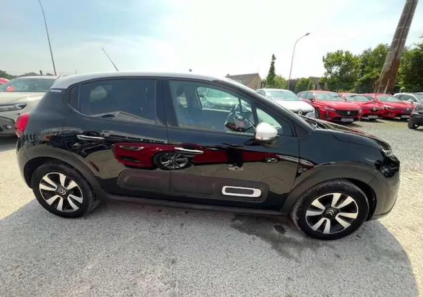 Citroën C3 noir toit blanc vue de profil côté gauche avec jantes alliage diamantées et inserts blancs sur les portières.