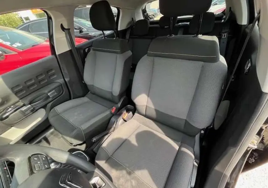Vue intérieure de la Citroën C3 2023 montrant les sièges avant gris et noir avec détails de la portière côté gauche.