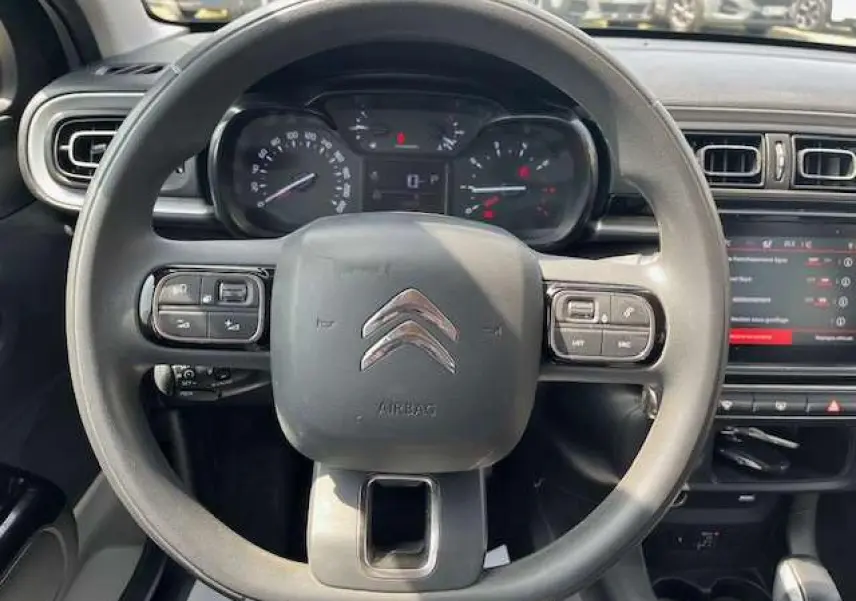 Vue intérieure centrée sur le volant noir de la Citroën C3 2023 avec tableau de bord et écran tactile visibles.