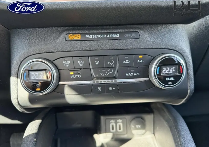Vue rapprochée de la console de climatisation bi-zone noire du Ford Kuga 2021 avec affichage digital à 22°C.