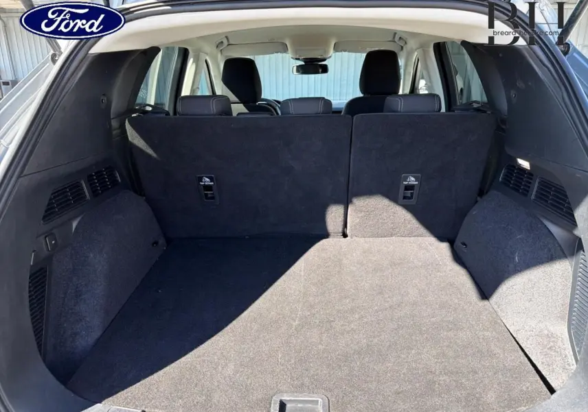Coffre spacieux du Ford Kuga 2021, vue de l'arrière avec banquette arrière noire en position relevée.