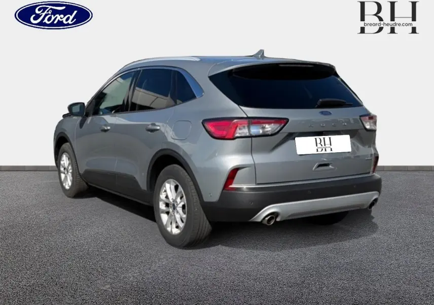 Ford Kuga gris Solar métallisé vu en 3/4 arrière droit avec vitres arrière surteintées et double sortie d’échappement.