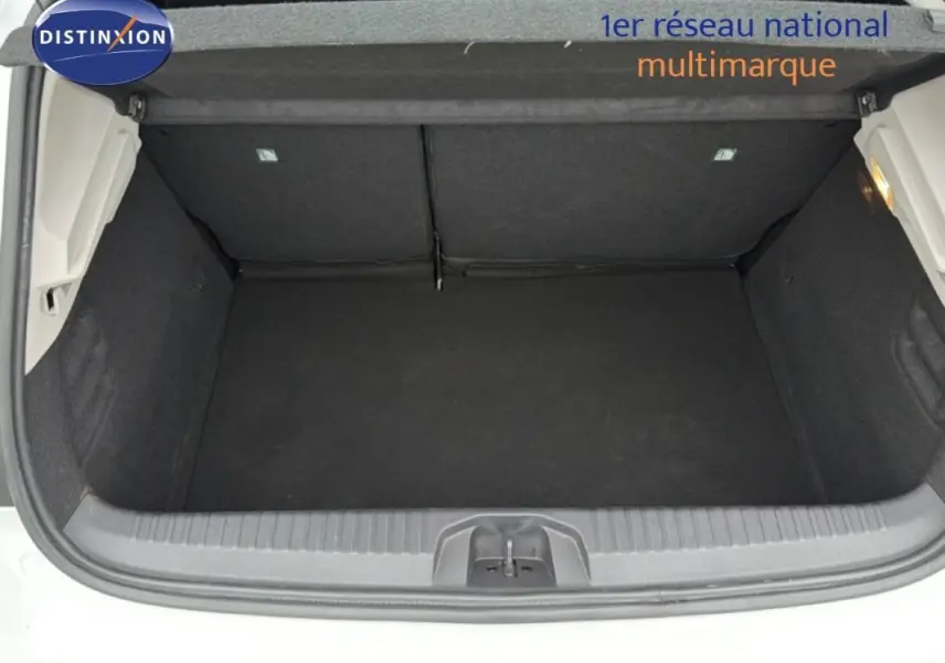 Coffre ouvert vu de l'arrière d'une Renault Clio blanche 2020, intérieur noir et espace de rangement vide.