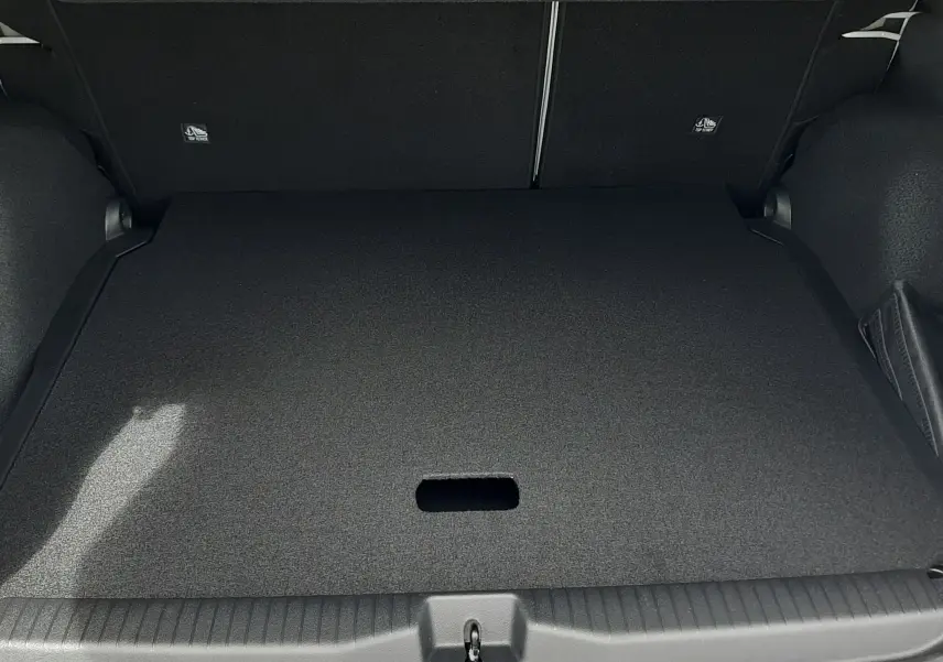 Coffre ouvert vu de l'arrière du Citroën C3 Aircross blanc banquise avec intérieur noir, plancher plat et espace de rangement.