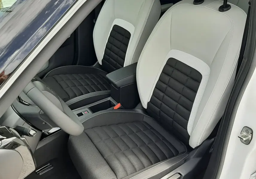 Vue intérieure côté conducteur du Citroën C3 Aircross 2026, sièges bi-matière noir et blanc avec surpiqûres contrastées.