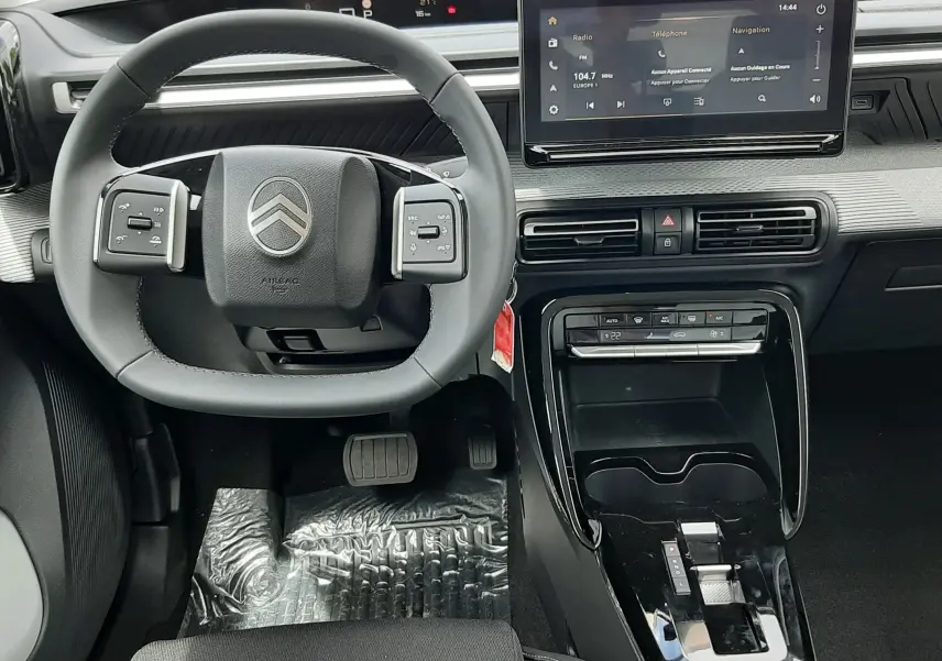 Vue intérieure avant du tableau de bord et volant Citroën C3 Aircross 2026, finition noire avec écran tactile central.
