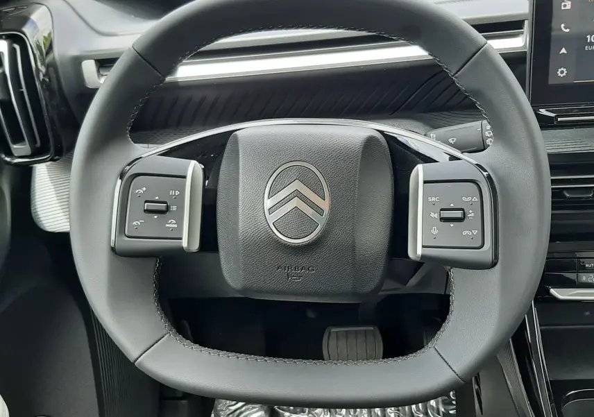 Vue rapprochée du volant carré noir de la Citroën C3 Aircross 2026, avec commandes intégrées et tableau de bord moderne.