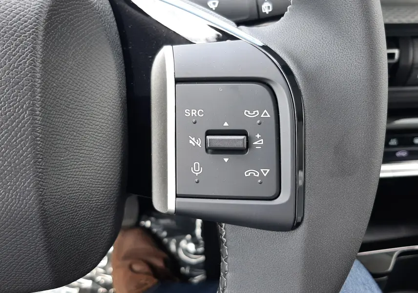 Gros plan sur les commandes gauche du volant noir du Citroën C3 Aircross 2026, avec boutons multifonctions visibles.