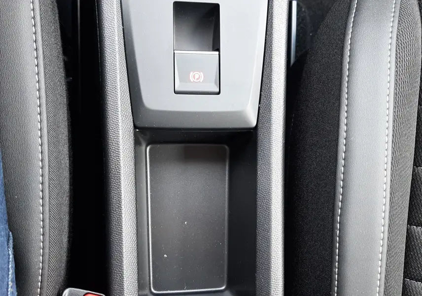 Vue plongeante sur la console centrale noire du Citroën C3 Aircross 2026, avec frein à main électronique et rangement vide.