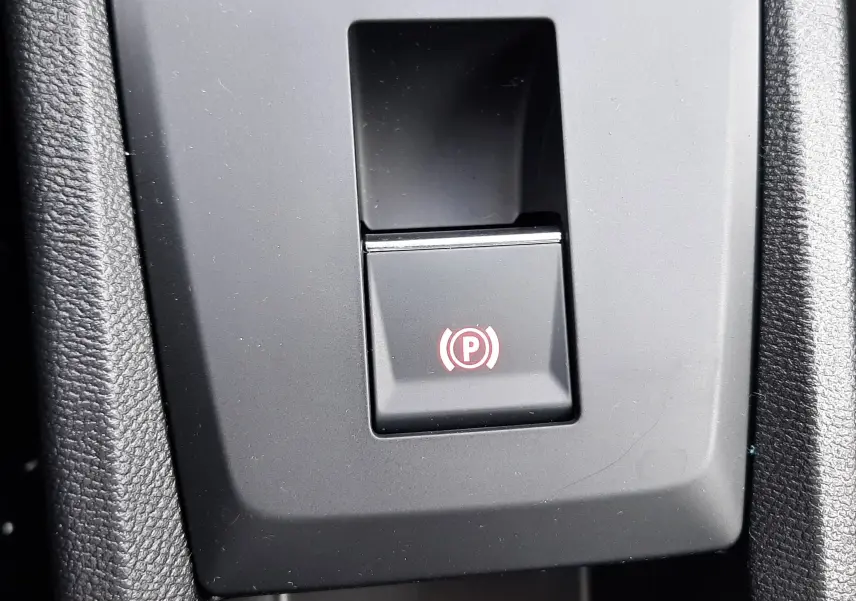 Bouton de frein de stationnement électronique dans l'habitacle de la Citroën C3 Aircross 2026 blanc banquise avec toit noir.